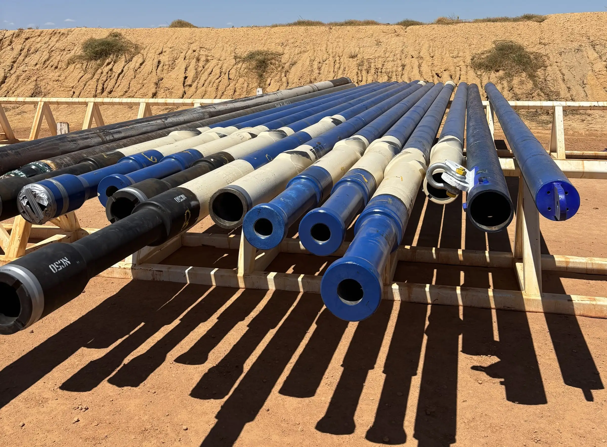 Core barrels laid out on racks at an onshore drilling site
