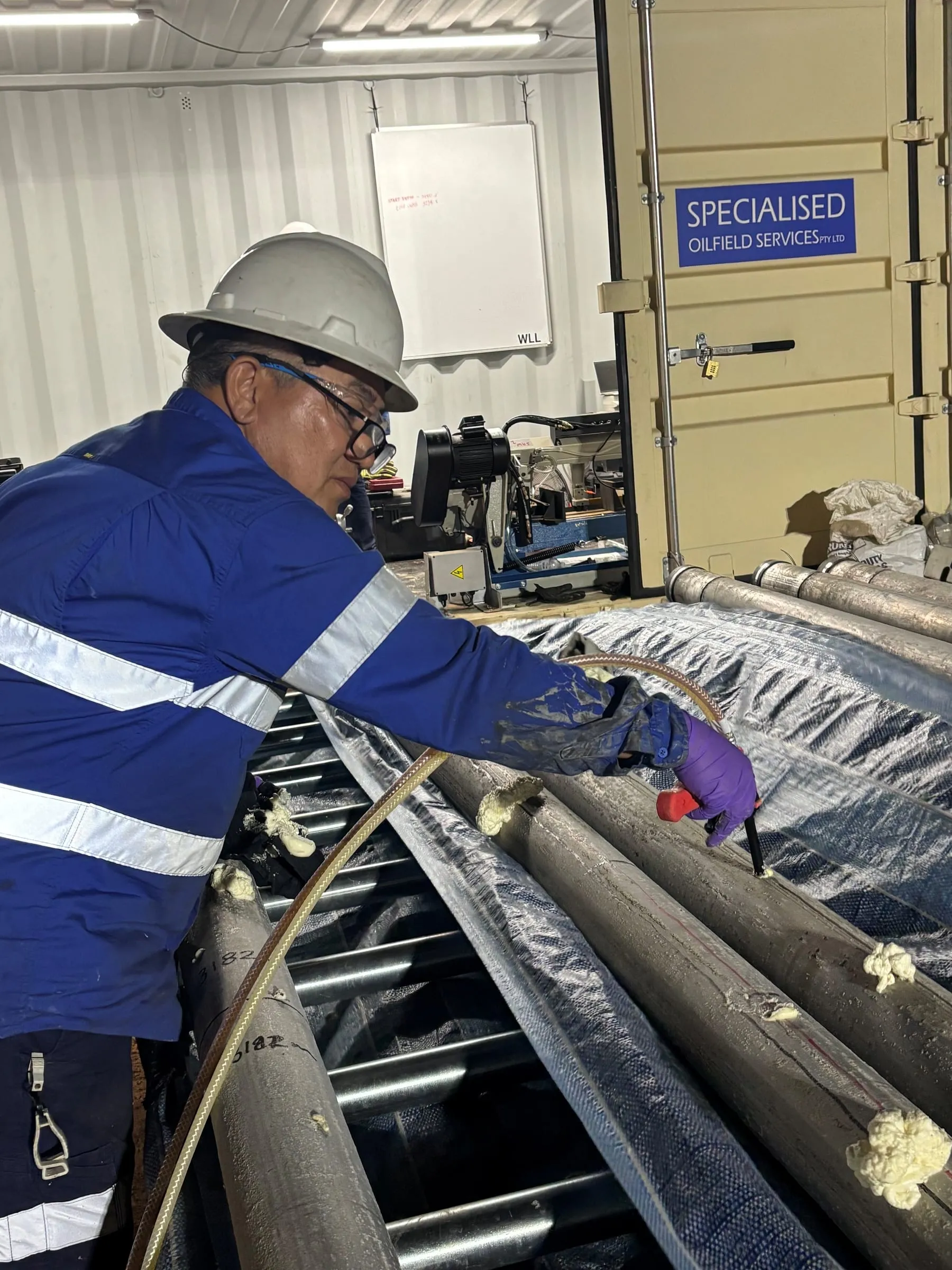 Engineer applying stabilising foam to core on the roller tables