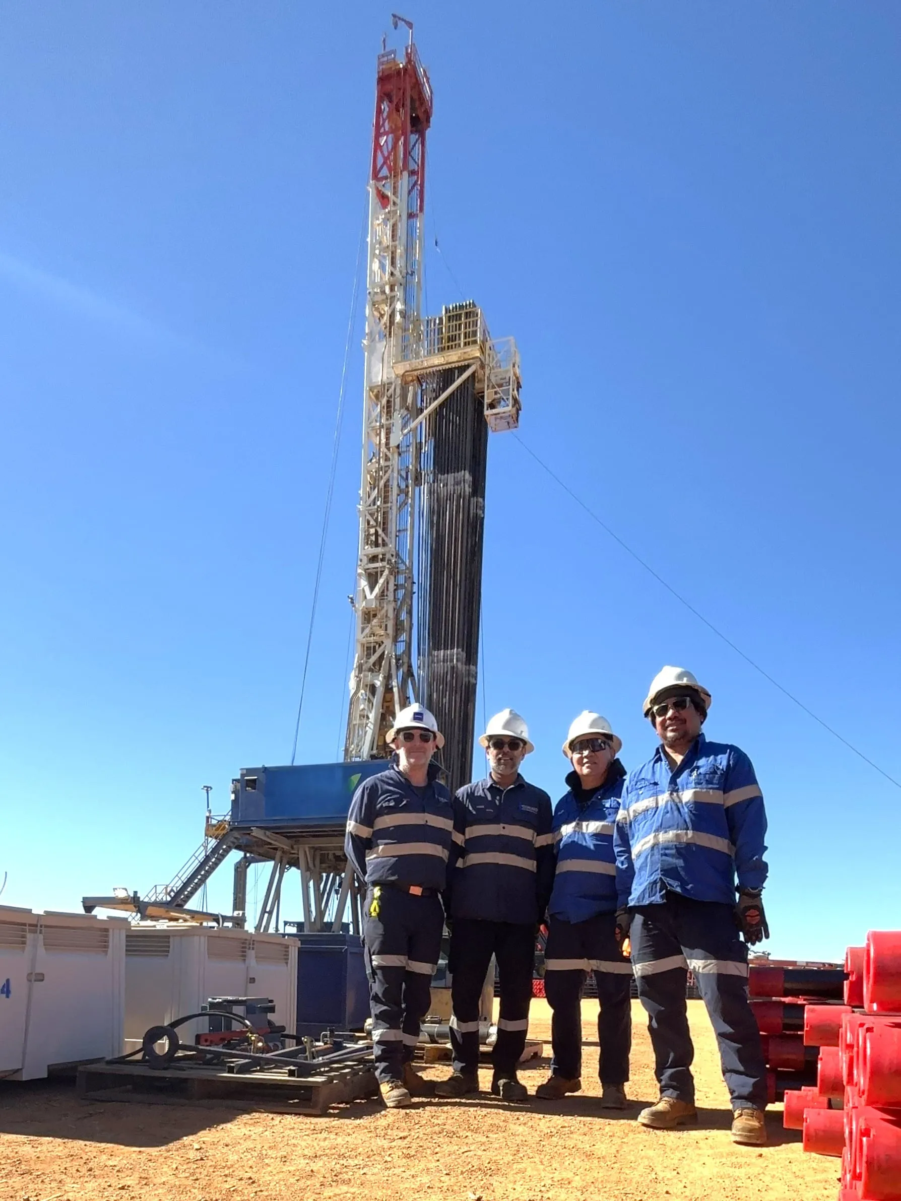 SOS coring team standing in front of an onshore drilling rig