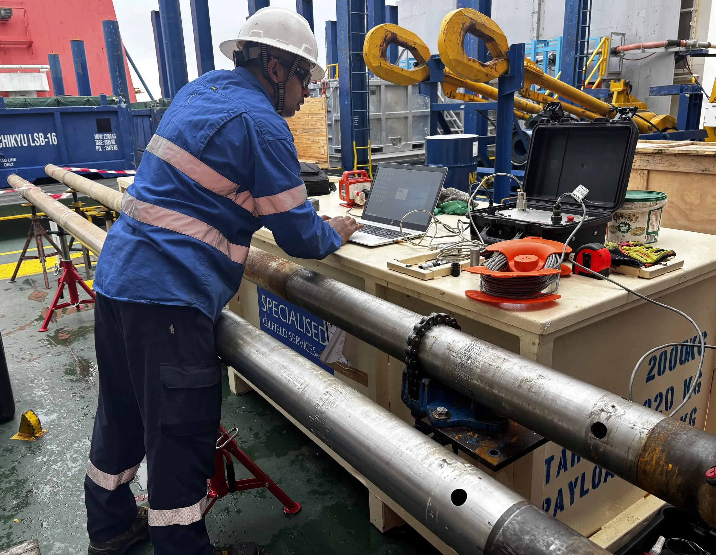 Coring engineer switching the SureCore on at a laptop beside the core barrels