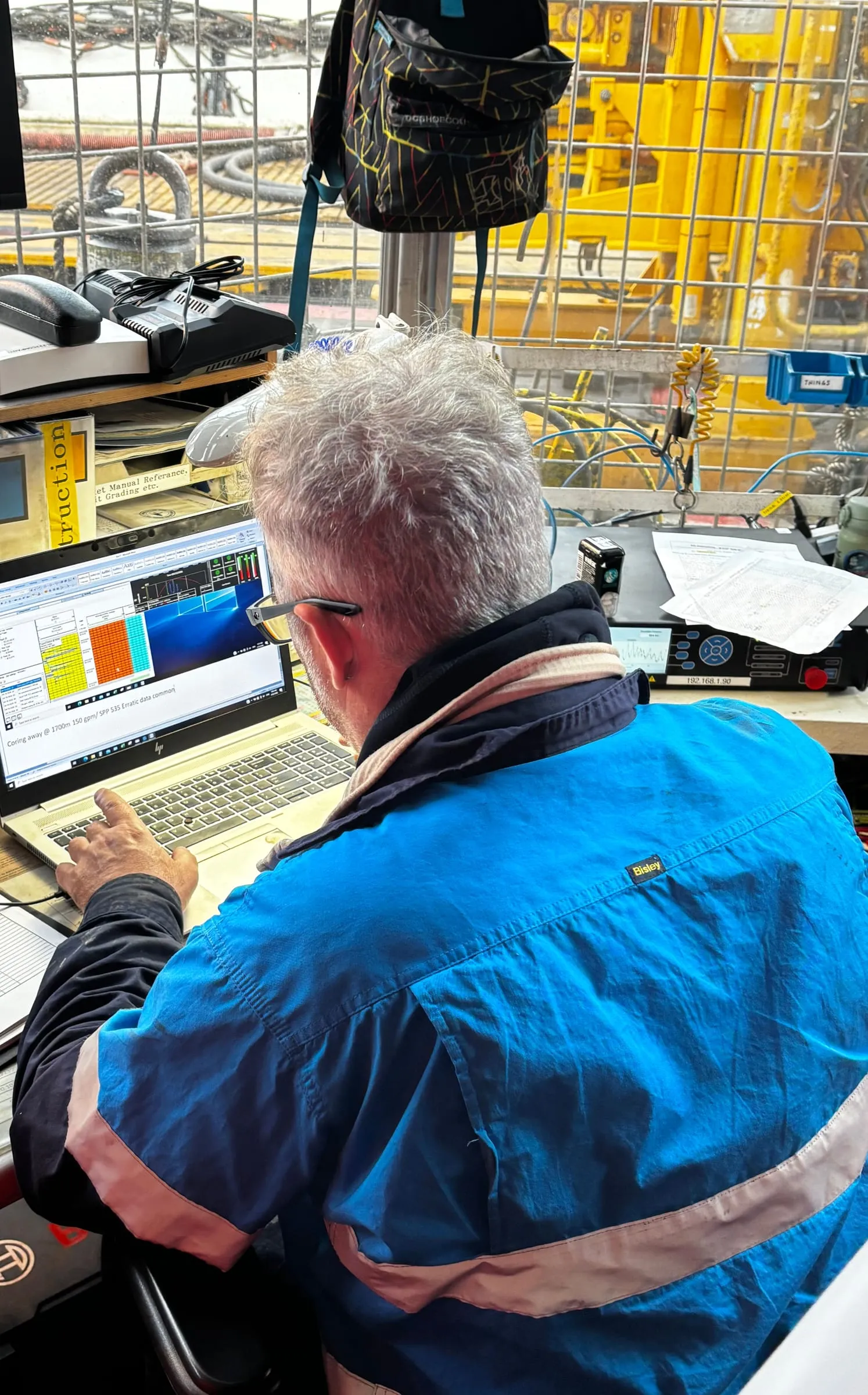 Coring engineer reviewing SureCore data on a laptop after a core run