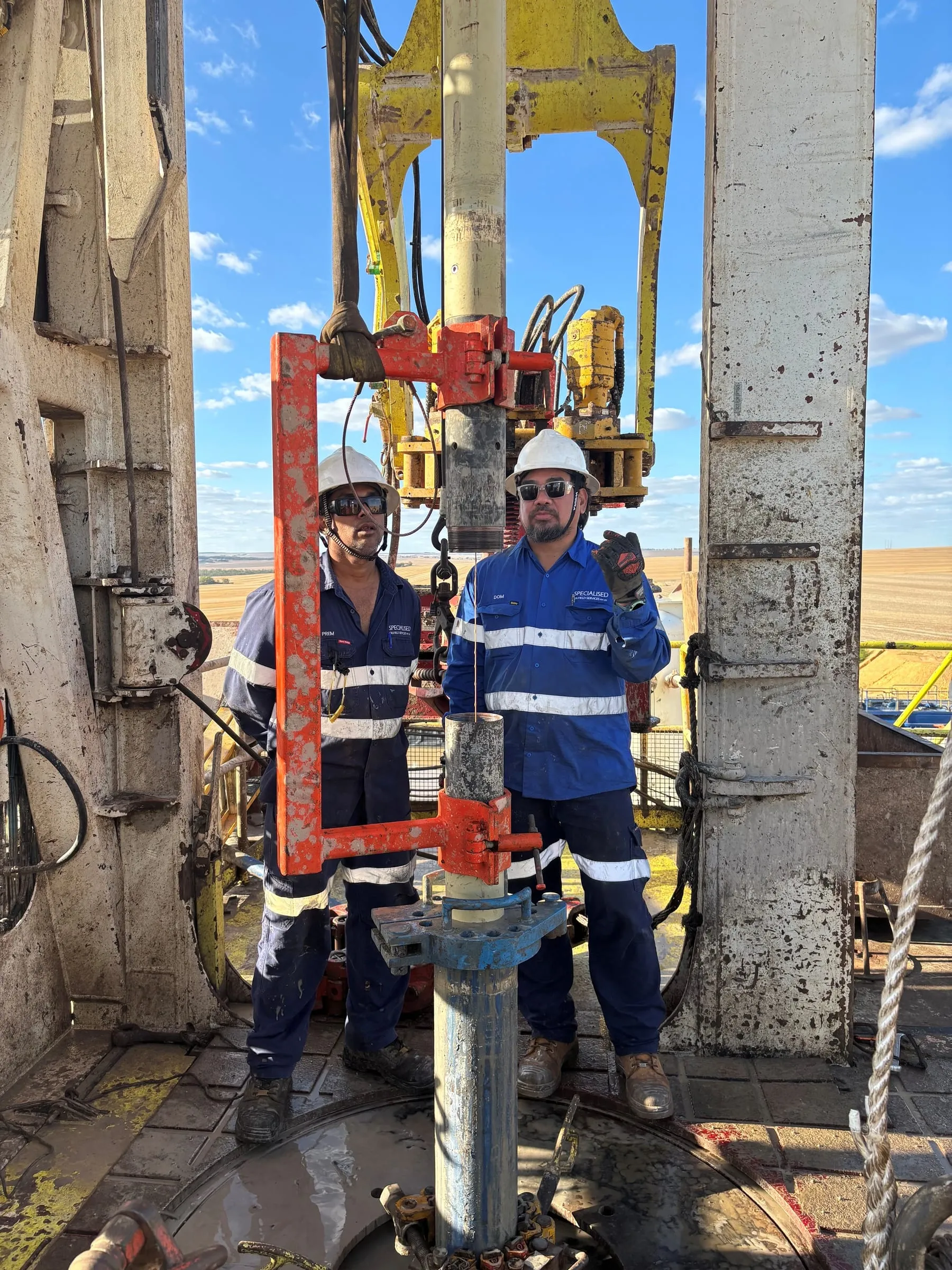 Two SOS engineers on the rig floor with the SureCore tool in its handling frame