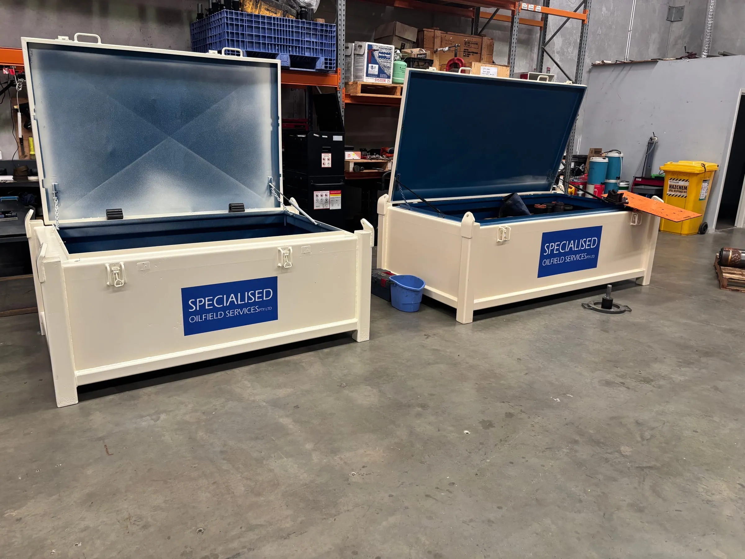 Two SOS-branded transit cases open on the workshop floor, packed for mobilisation